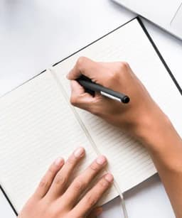 Hand writing with pen on paper with geometric shapes